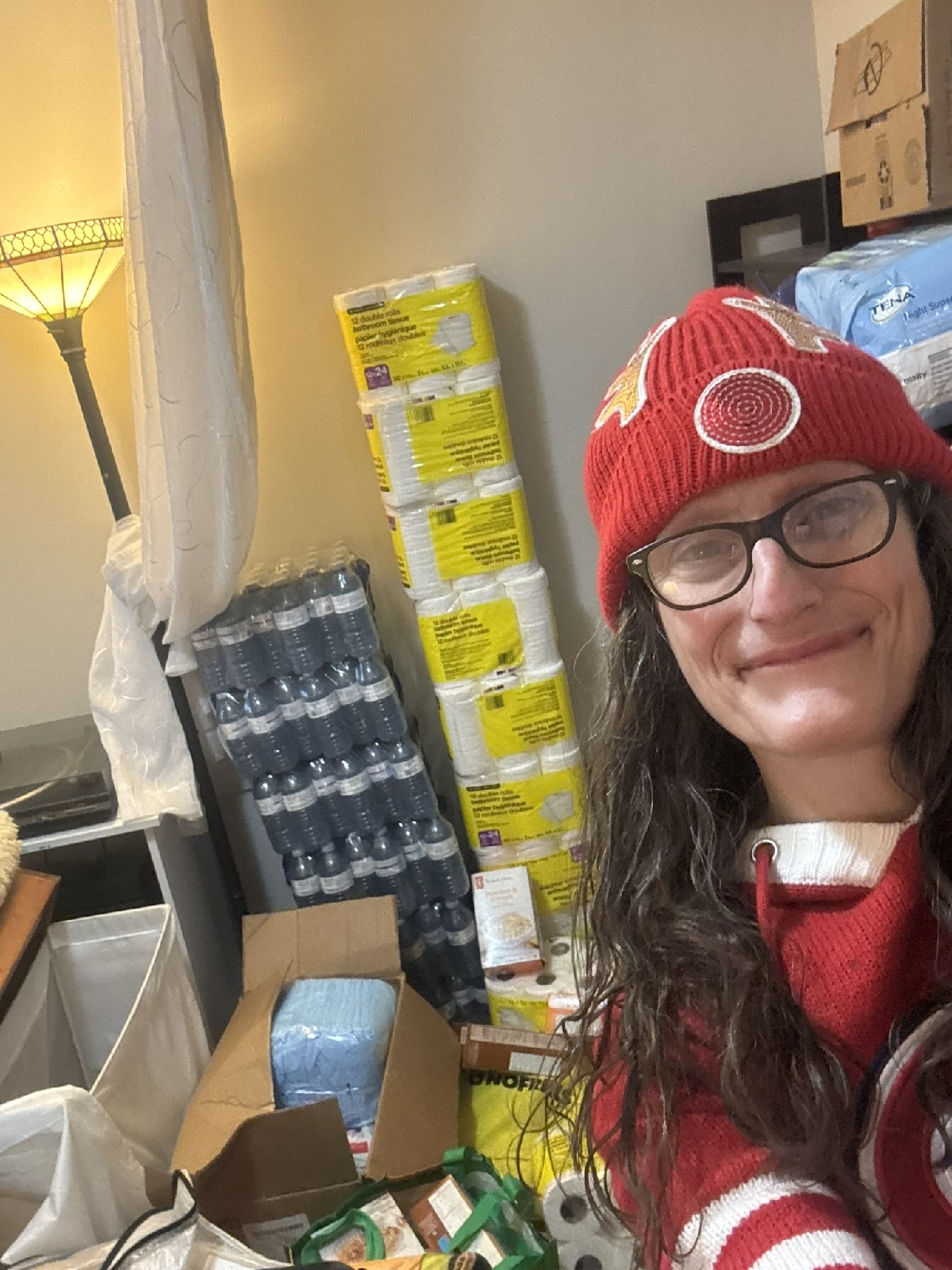 Adriana Violo with stacks of donated supplies for the Christmas Care Pack Drive
